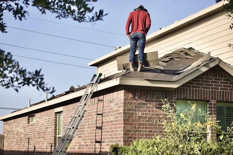 Professional roofer working on a residential roof in Barkhamsted